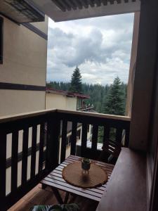a small table on a balcony with a view at Апартамент почивка в планината in Pamporovo