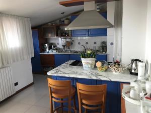 uma cozinha com armários azuis e um balcão com cadeiras em Dimora Spina em Ferrazzano