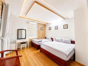 a bedroom with a bed and a couch and a window at Loankim Homestay in Hue