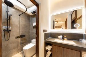 a bathroom with a sink and a toilet and a mirror at Elsewhere Hotel Inn Ancient City Center Branch in Pingyao +70 photos
