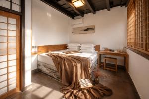 a bedroom with a bed with a blanket on it at Elsewhere Hotel Inn Ancient City Center Branch in Pingyao