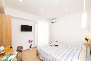 a bedroom with a bed and a table and a tv at Le 3 Viste B&B in Vieste
