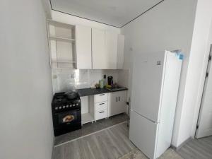 a kitchen with white cabinets and a refrigerator at Diamond resort in Bosteri