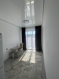 an empty room with a table and a window at Diamond resort in Bosteri