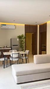 a living room with a couch and a table and chairs at بالم هيلز Palm Hills in Baljurashi