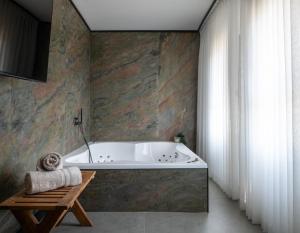 a bath tub in a bathroom with a stone wall at בוטיק אשתאול - 4 סוויטות מפנקות עם ג'קוזי פרטי ו2 בריכות במתחם in Eshtaol