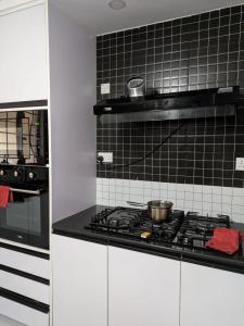 a kitchen with a stove with pots and pans on it at Hidden Gem KAG Kitengela in Stony Athi