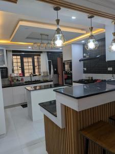 a kitchen with black and white counter tops and lights at Hidden Gem KAG Kitengela in Stony Athi +12 photos
