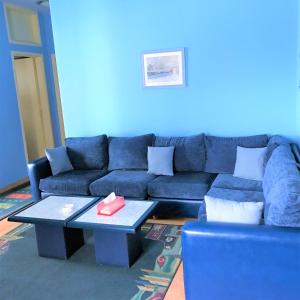 Sala de estar azul con sofá y mesa en Stone Chalets, en Fārayyā