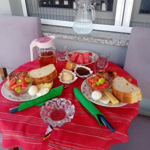 a table with plates of food on a red table cloth at Bujtina4A Rrenc in Renc