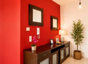 a room with a red wall with a desk and mirror at Holiday Lefkas Moonlight Luxury Appartments in Nikiana +36 photos