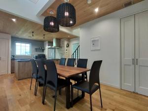a kitchen and dining room with a wooden table and chairs at マークヴィラスイート in Shimo-suwa
