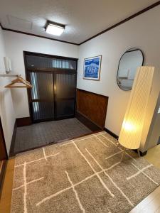an empty room with a door and a mirror at Kuro House Myoko in Myoko