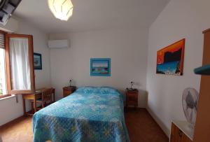 a bedroom with a bed with a blue comforter at B&B Marino E Lily in Baratili San Pietro +20 photos
