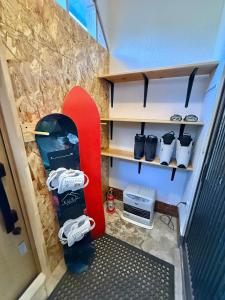 a room with a snowboard in a small room at Kuro House Myoko in Myoko