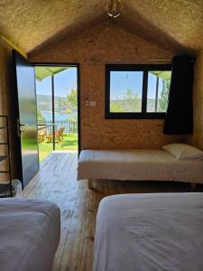 a room with two beds and a view of the ocean at מאי טאי ויליג' - 8 בקתות מהממות מול הנוף in Mas'ada