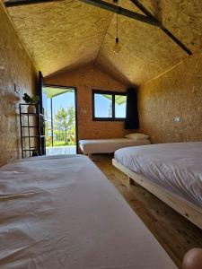 a room with two beds and a window at מאי טאי ויליג' - 8 בקתות מהממות מול הנוף in Mas'ada
