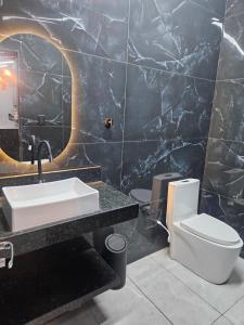 a bathroom with a sink and a toilet at Recanto JF in Pirapora +10 photos