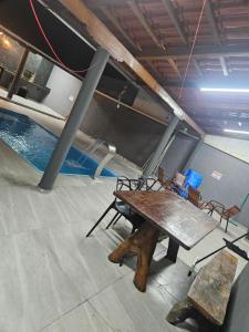 a table and chairs in a room with a pool at Recanto JF in Pirapora