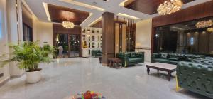 a lobby with green leather couches and a table at The Vaishnavi Hotel , Buxar Bihar in Buxar +2 photos