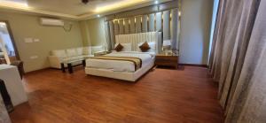 a bedroom with a bed and a couch and a chair at The Vaishnavi Hotel , Buxar Bihar in Buxar