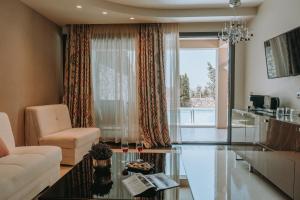 a living room with a couch and a glass table at Sivota Diamond Spa Resort in Syvota