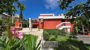 a red building with a garden in front of it at Polaroid House '76 in Radovici