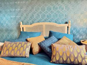 a group of pillows on a bed with a wall at Les Roses de Montherlant in Montherlant