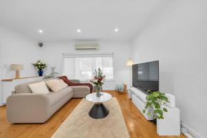 a living room with a couch and a tv at 11 Guests 6BR, Granny Flat, 3 Kitchens, Hiking in Dernancourt