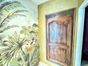 a door in a room with a mural of plants at Les Roses de Montherlant in Montherlant