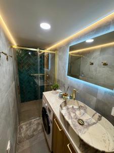 a bathroom with a sink and a washing machine at The Emerald Loft I Terrace I Free Parking in Kaunas +20 photos
