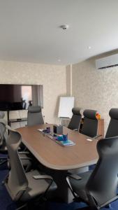 a conference room with a wooden table and chairs at Twelve Hotel in Baghdād