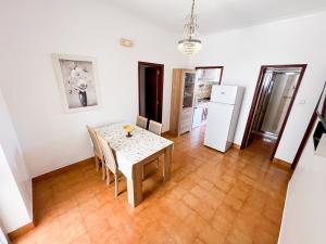 a kitchen and dining room with a table and refrigerator at Encanto da Praia in Santo André