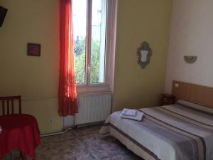 a bedroom with a bed and a window at Hotel Acapulco in Montpellier