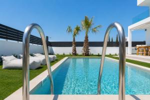 a swimming pool in a yard with palm trees at Martini Villas in Kremasti