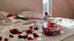 a bunch of roses on a bed with a box at VikendicaDM in Hrvačići