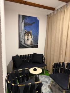 a living room with a couch and a wolf painting at VikendicaDM in Hrvačići