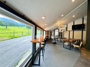 a dining room with a table and a large window at Hakuba Sun Valley Hotel in Hakuba