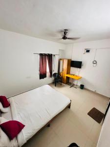 a bedroom with a large bed and a desk at Hotel Deluxe in Hinjewadi