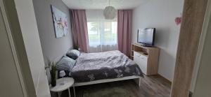 a small bedroom with a bed and a television at Ferienwohnung Toge in Wadgassen