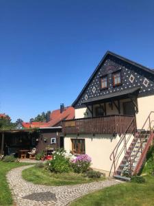a house with a wooden balcony and a walkway at FEWO Schulze Jonsdorf, Waldblick in Kurort Jonsdorf