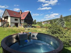 a hot tub in the yard of a house at FEWO Schulze Jonsdorf, Waldblick in Kurort Jonsdorf +10 photos