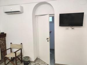 a room with a door with a tv on a wall at VisitPonza - Le Naiadi in Ponza
