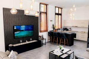 a living room with a tv and a kitchen with a table at Kensington Villa - Private Pool & Rooftop Terrace by Azur Prime in Ayios Yeoryios