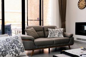 a living room with a couch and a tv at Kensington Villa - Private Pool & Rooftop Terrace by Azur Prime in Ayios Yeoryios