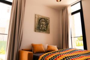 a bedroom with a bed and a painting of a head at Kensington Villa - Private Pool & Rooftop Terrace by Azur Prime in Ayios Yeoryios +40 photos
