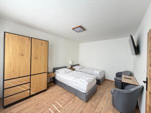 a bedroom with two beds and a cabinet at Apartmánový byt Kostička 7 in Kadaň