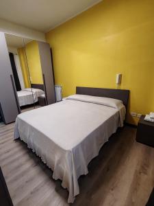 a bedroom with a large bed in a yellow wall at Il Codibugnolo-casa vacanze Arezzo in Arezzo +4 photos