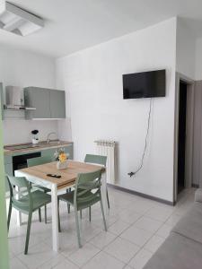 a kitchen with a table and chairs and a television on the wall at Il Codibugnolo-casa vacanze Arezzo in Arezzo