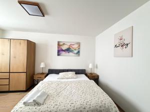 a white bedroom with a bed and two night stands at Apartmánový byt Kostička 7 in Kadaň